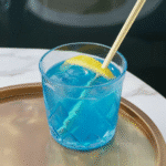 Blue Salt Trick – A detox water glass with visible blue salt crystals, cucumber slices, and a lemon wedge.