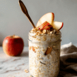 Side view of apple cinnamon overnight oats topped with apples and cinnamon